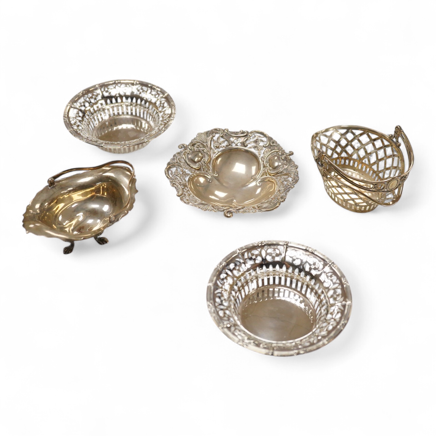 A pair of pierced silver circular bonbon dishes, maker JM, Birmingham, 1906, diameter 10.3cm, together with one other silver bonbon dish and two bonbon baskets, one silver, one stamped with U.S. sterling marks, 7.1oz.